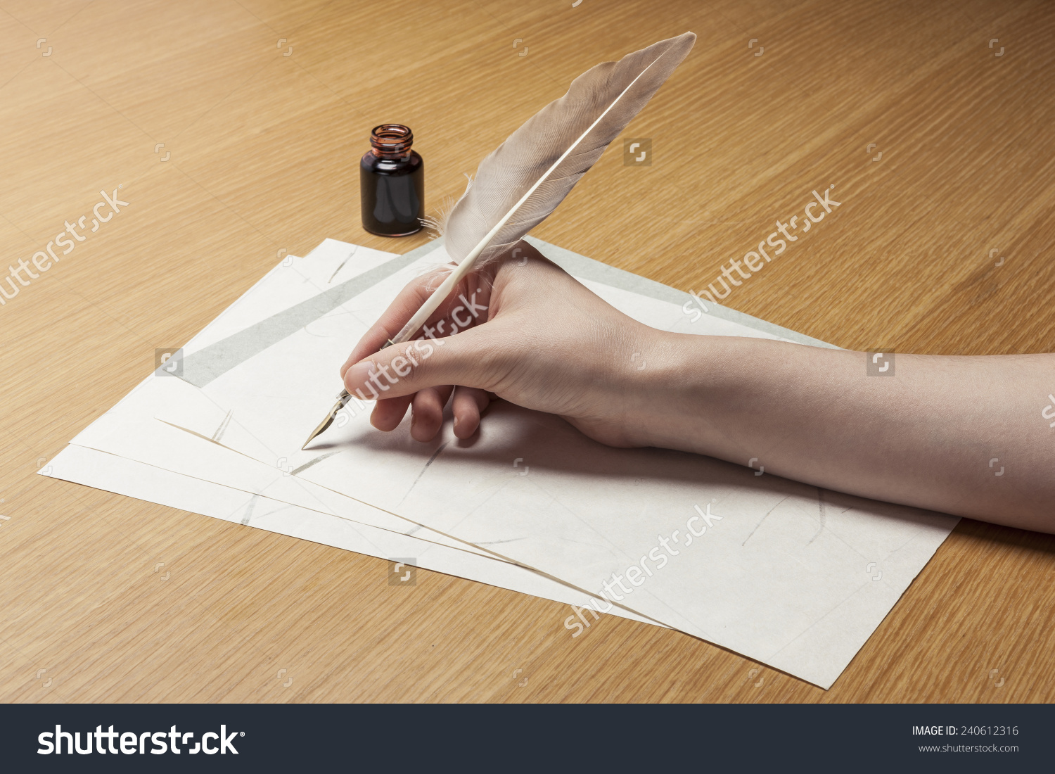 stock-photo-a-female-woman-hand-hold-write-a-feather-quill-pen-with-ink-on-the-letter-paper-and-wood-desk-240612316